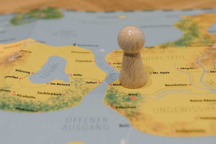 Eine hölzerne Spielfigur steht auf einer Landkarte.